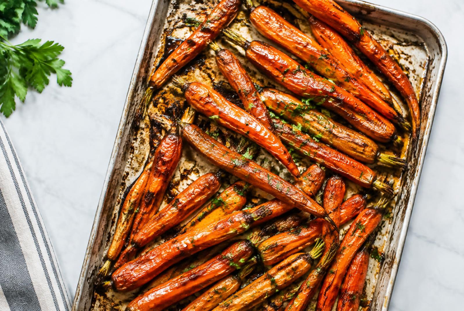 Honey Garlic Roasted Carrots served in a shallow ceramic bowl
